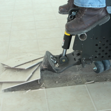 Ride-on scraper removing ceramic tiles.