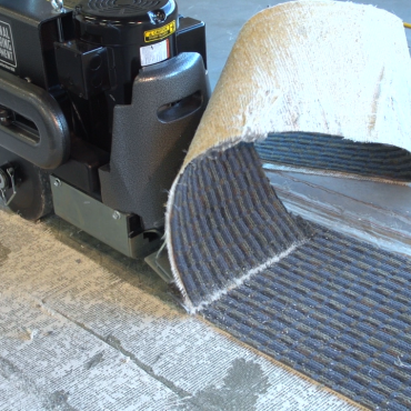Walk-behind scraper removing carpet
